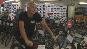Roger Harrfors cykelpendlar själv till jobbet varje dag. Hans jobbväg är 15 km och han säger att han är lika snabb på elcykel, som om han skulle köra bil och tvingas stå i bilköer. Roger Harrfors sitter på en cykel i sin cykelaffär.