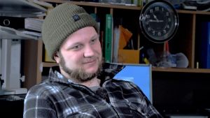 Anders Granfors jobbar två veckor ute till sjöss och är sedan i land två veckor. Fiskaren Anders Granfors sitter i kontoret med mössa på huvudet.