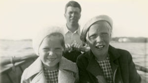 Meri Louhos pikkutyttönä soutuveneessä siskonsa ja isänsä kanssa.