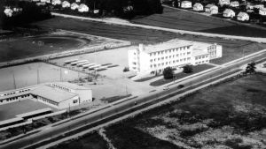 Så här såg nybyggena ut i slutet av 1950-talet på Skolgatan - till höger Sarlinska skolan, till vänster Paraistenseudun koulu. Nu ska fastigheterna på bilden rivas för att ge plats för det nya. Mellan skolorna finns i dag det svenska gymnasiet som kommer att renoveras och ska stå kvar tillsammans med nybygget. Svartvit bild fotograferad från luften så att man ser Sarlinska skolan och Paraisten seudun koulu. Svenska gymnasiet är ännu inte byggt här.