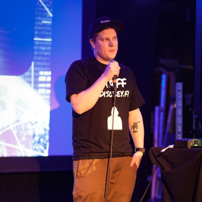 Benjamin står på en scen med en mikrofon i handen. Han ser lite nervös ut.