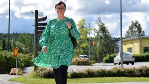Språkfrågan är en viktig del i reformen, säger kommundirektör Anneli Pahta. Anneli Pahta, i en grön klänning, går över ett övergångsställe.