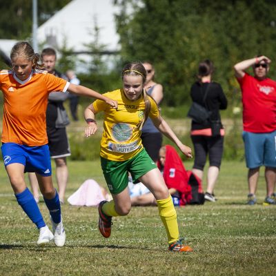 Tyttöjä pelaamassa jalkapalloa.