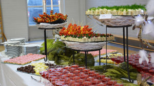 Efter festprogrammet fick elever och personal ta åt sig av en massa godheter. På ett bord står skålar och fat fyllda med sötsaker och små salta bitar. Vinglas är fyllda med röd saft.