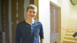 Anton Salminen hoppas att den nya skolan hålls fri från mögel. En pojke står inne i ett halvfärdigt hus. Han tittar in i kameran och ler.
