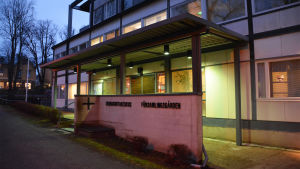 Det skulle bli alltför dyrt att renovera Lovisa församlingsgård, så huset hamnade i stället på listan över fastigheter man ska göra sig av med. En byggnad upplyst med lampor i mörkret. Huset är vitt med svarta detaljer. Utanför står det Församlingsgården.