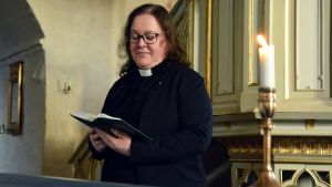Janette Lagerroos tror att doptraditionen blivit obekant för många. Prästen Janette Lagerroos i en kyrka med en bibel i handen.