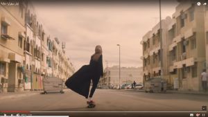 Skärmdump av Nikes reklamvideo. Skärmdump av video: Kvinna i hijab åker rullbräde med kappan fladdrande efter sig i en omgivning som ser ut att vara i Mellanöstern.