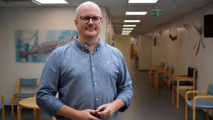 Chefläkare Sami Salminen anser att det inte finns skäl till oro över vaccinerna. Sami Salminen står i en sjukhuskorridor.