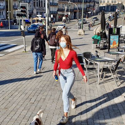 En ung kvinna rastar sin hund i Portos centrum.
