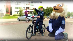 En pojke i poliskläder och polislejonet i ett videoklipp.