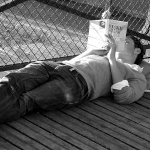 Ung man läser Albert Camus i Paris.