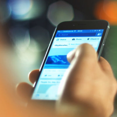 En person är inne i Facebook-applikationen på sin smarttelefon.