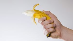 Stopp och belägg! Ät en banan på direkten! Nej, det behövs egentligen inte. En hand som håller i en banan.