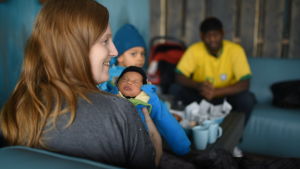 Lotten, Celine, Lucas och Oneil Walker. Lotten Walker med sin nyfödda bebi och familjen i bakgrunden