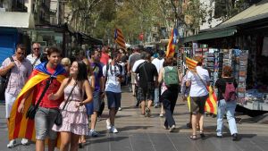Jalankulkijoita ja lippuja Barcelonan Ramblalla.
