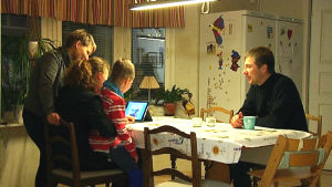Familjen Johansson har hittat sina rutiner. Familjen Johansson runt köksbordet och en datorskärm.