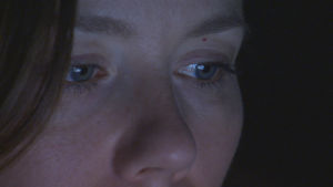 naisen silmät kylpevät älylaitteen sinisessä valossa