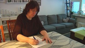 Christel Nordström ansöker om utkomststöd en gång i månaden. En kvinna sitter vid ett bord och skriver. Hon heter Christel Nordberg och ansöker om utkomststöd i Raseborg.