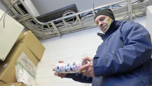 Tullinspektör Tuomo Kunnari i tullens förråd i Torneå. Tullinspektör Tuomo Kunnari i Torneå håller i ett torn snus i tullens förråd.