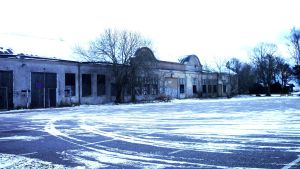 Fabriksudden 2009 innan några avtal var undertecknade. En gammal låg lång stenbyggnad i blått vinterljus, lite snö på marken.