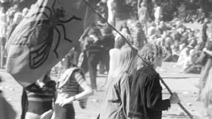 Nuori pariskunta kantaa kärpäsen kuvalla varustettua lippua Ruisrockissa 1970.
