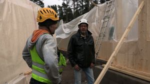 Kaksi miestä keskustelevat rakennustyömaalla