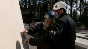 Vastaava kirvesmies Esa Dahl ja rakennuttaja Juha-Pekka Ristmeri tutkivat clt-elementin laatua. Miehet tutkivat elementin laatua rakennustyömaalla