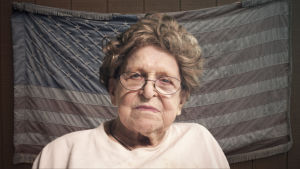 Iäkäs nainen Yhdysvaltain lipun edessä.