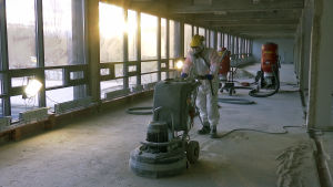 Mies poistaa asbestia rakennustyömaalla.