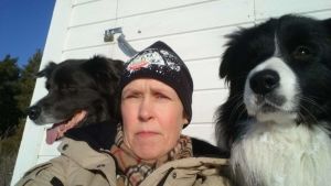 Agneta Andersson med läshunden Fly (till höger). Agneta Andersson poserar tillsammans med två hundar.