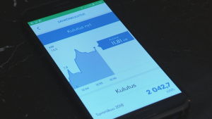Jani Leirimaa pekar på Fortums nätverk av hushåll vars varmvattenberedare fungerar som virtuellt batteri. Fortums app som visar elförbrukningen i ett hushåll.