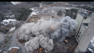 Ett moln av damm efter att byggnaden kollapsar. Rök och damm efter en explosion.