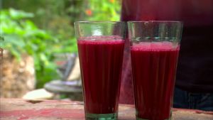 Smakrik och färgstark råsaft av morot, rödbeta och palsternacka Två glas röd rotsakssmoothie