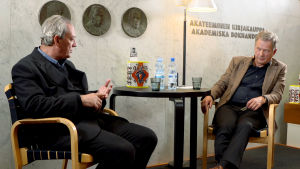 Kirjailija Paul Auster ja presidentti Sauli Niinistö istuvat ja keskustelevat.
