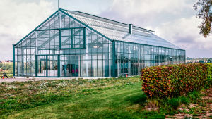 Ett hus inuti ett annat - en speciell husdröm. Bild av ett speciellt hus som liknar ett hus inuti ett växthus.