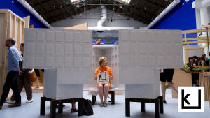 Minna Joenniemi istuu pienoismallin sisällä penkillä Venetsian biennaalissa