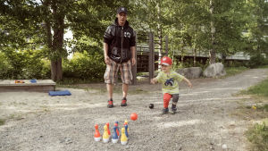 Luca-Emil Mykkänen keilaa ulkona isänsä Joonas Blombergin kanssa.