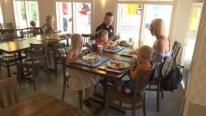 Alexandra, Willy och Winston Sjöholm med sina föräldrar. En familj med mamma, pappa och tre barn sitter vid ett restaurangbord.
