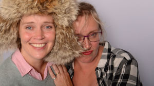 Ohjaaja Tiina Lymi ja toimittaja Olga Ketonen Radio Suomen Illassa. Tiina Lymi karvahattu päässään iloisena Olga Ketonen vierellään