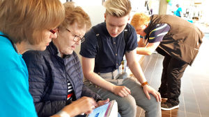 Kaksi digiauttajaa neuvoo eläkeikäistä naista Rovaniemen pääkirjastolla.