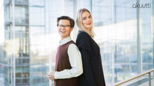 Sami Sykkö ja Marja Kihlström seisovat selät vastakkain Helsingin keskuskirjasto Oodin suuren ikkunan edessä.