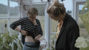 Maria Holmberg visar Märta Westerlund hur hon doserar sitt insulin med hjälp av en insulinpump. En kvinna med diabetes visar för programledare Märta Westerlund hur hon doserar sitt insulin.