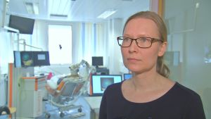Hanna Sahlsten, öronläkare som har doktorerat i ämnet tinnitus. I bakgrunden syns en patient som får TMS-behandling. Hanna Sahlsten, öronläkare som har doktorerat i ämnet tinnitus.