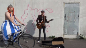 Du får själv hjälpa till att sjunga låten färdigt när trubaduren kommer av sig. Obelix rider på cykel förbi en gatumusikant.