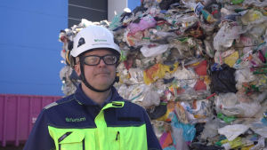 Mikko Koivuniemi hoppas att det sker förändringar kring produkter av återvunnen plast. En nöjd man framför plastbalar.