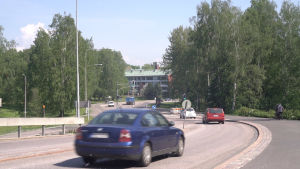 Labbackavägen har flera farthinder och trafikljus. Bilar kör för Labbackavägen i Munksnäs under en solig sommardag.