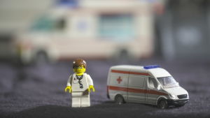 Förebyggande vård minskar på behovet av sjukvård. En leksaksdoktor som står bredvid en leksaksambulans på en filt.
