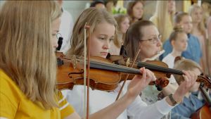 Sommarpsalm från Åland med violinister från Raseborgs musikinstitut. Tre unga kvinnor spelar violin i kyrka.