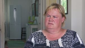 Ulla Jensen säger att hon blivit rädd för att röra sig ute sedan elsparkcyklarna kom till Helsingfors. En kvinna i kort blont hår sitter i en stol i sitt hem.